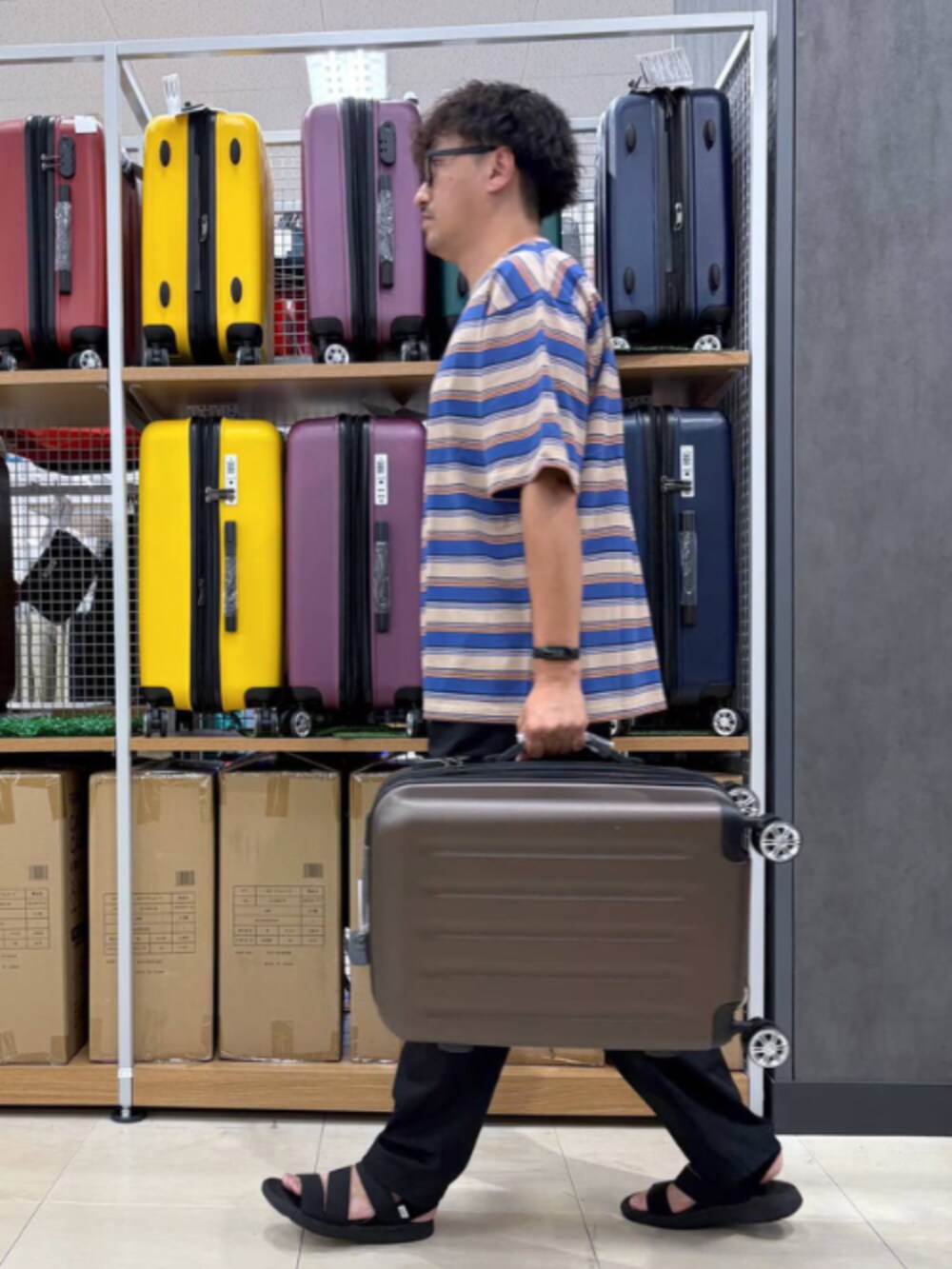 ブラウン系のスーツケース/キャリーバッグを着用したメンズの秋コーディネートの3枚目の写真