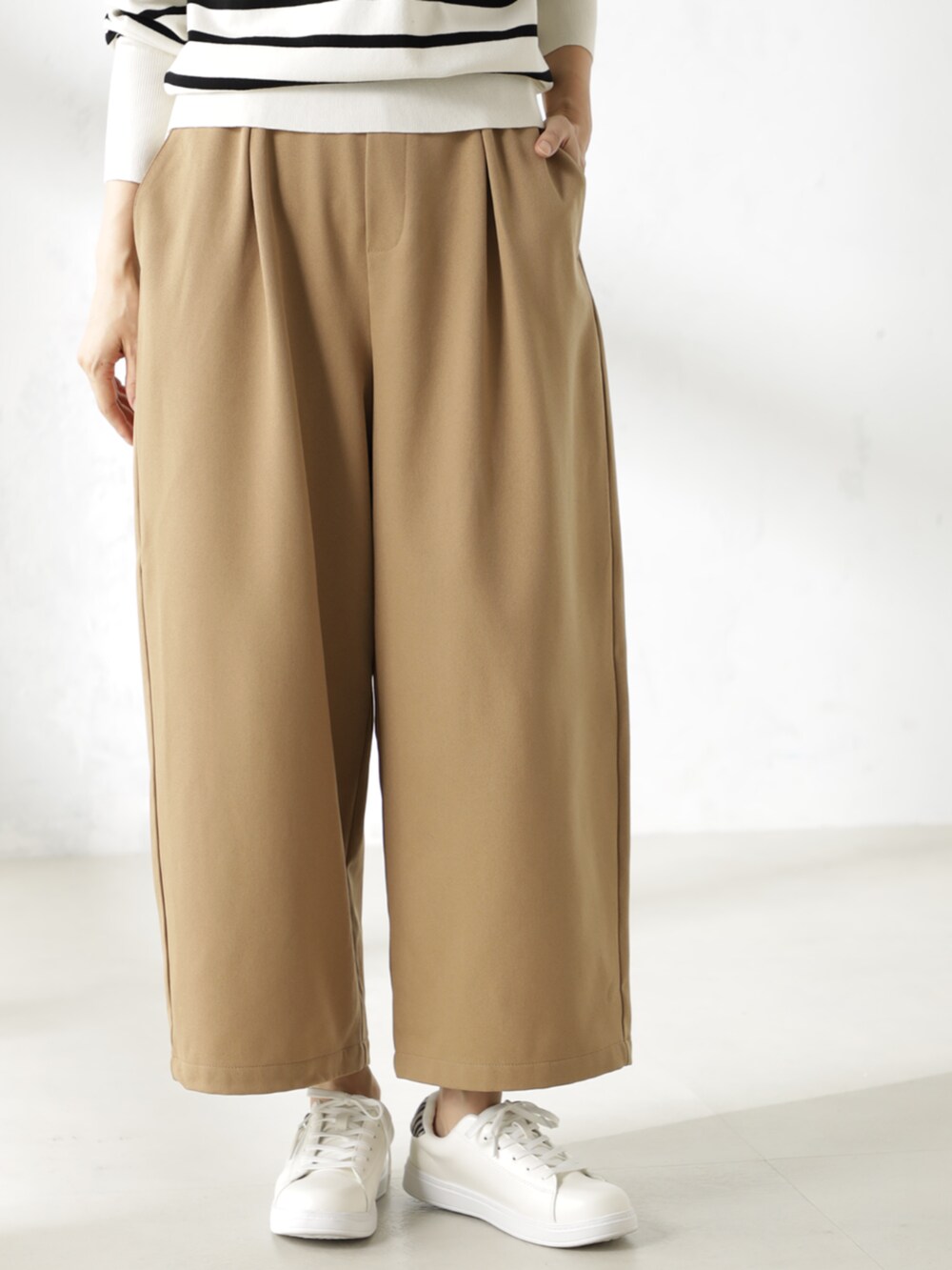 グレー系のニット/セーター、ベージュ系のその他パンツを着用したレディースの冬コーディネートの2枚目の写真