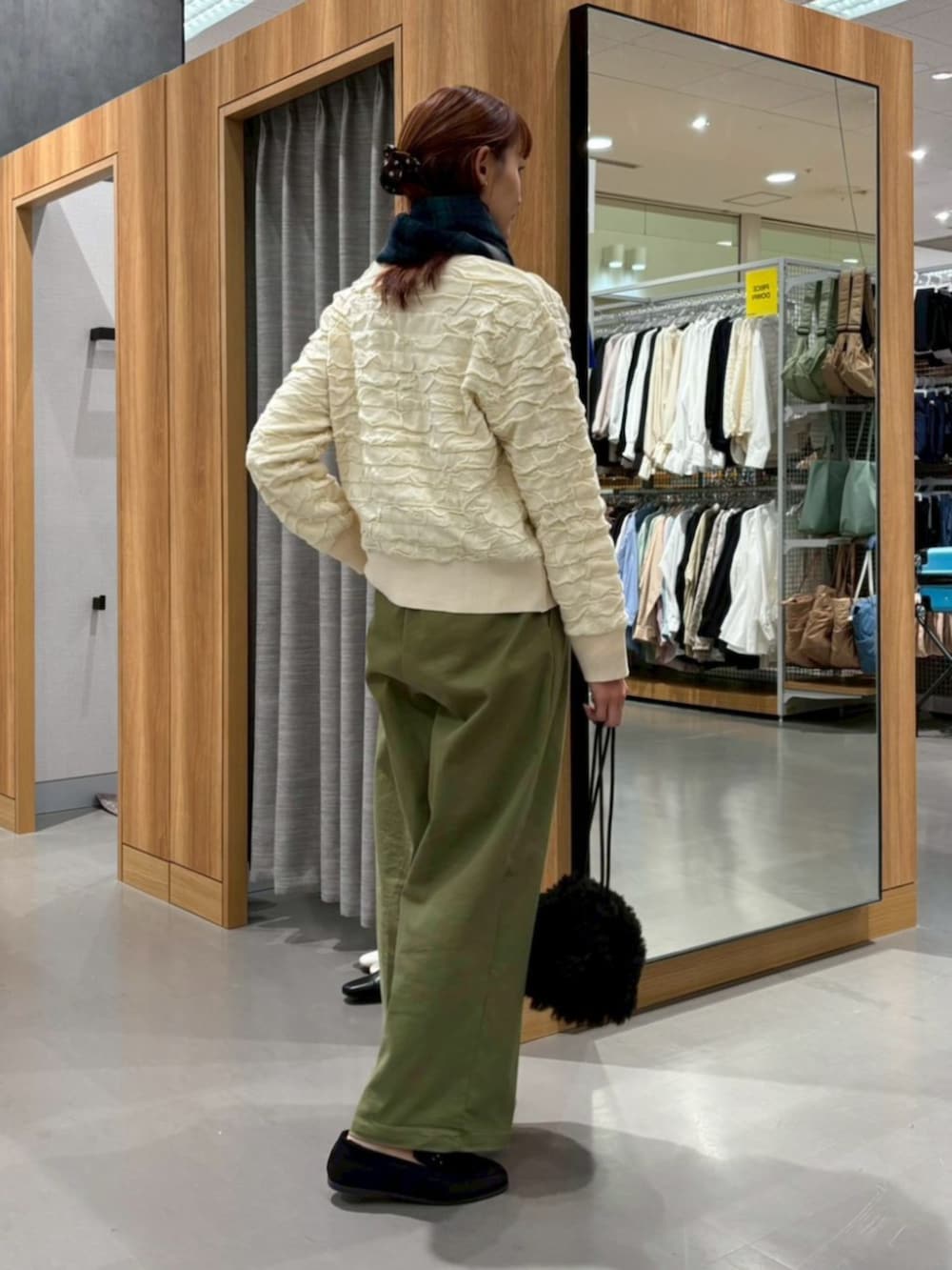 ベージュ系のカーディガン/ボレロ、グリーン系のマフラーを着用したレディースの冬コーディネートの2枚目の写真