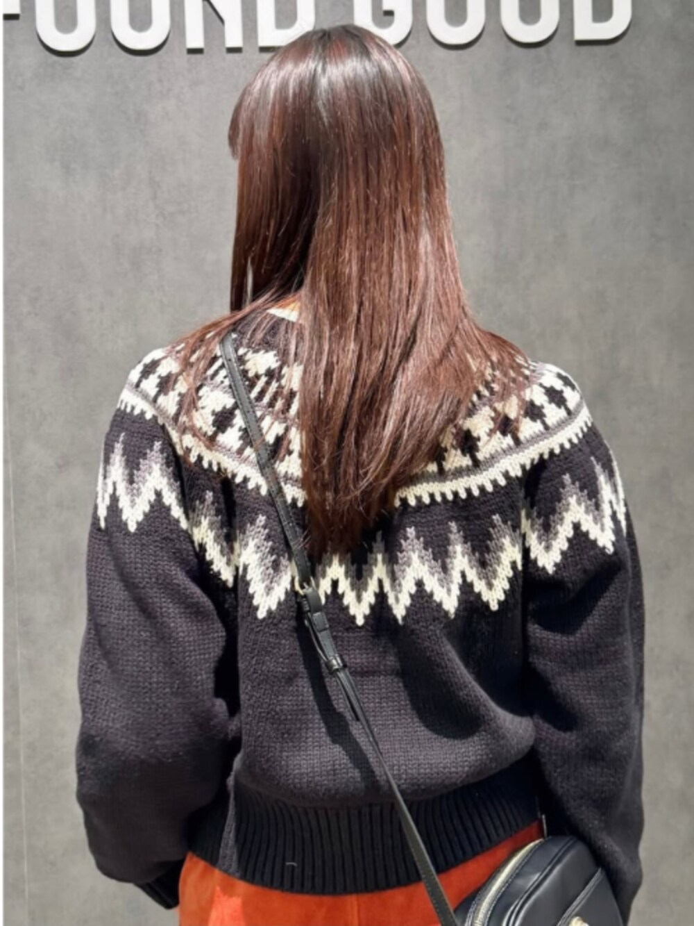 オレンジ系のその他パンツ、ブラック系のショルダーバッグ、ブラック系のニット/セーターを着用したレディースの冬コーディネートの3枚目の写真