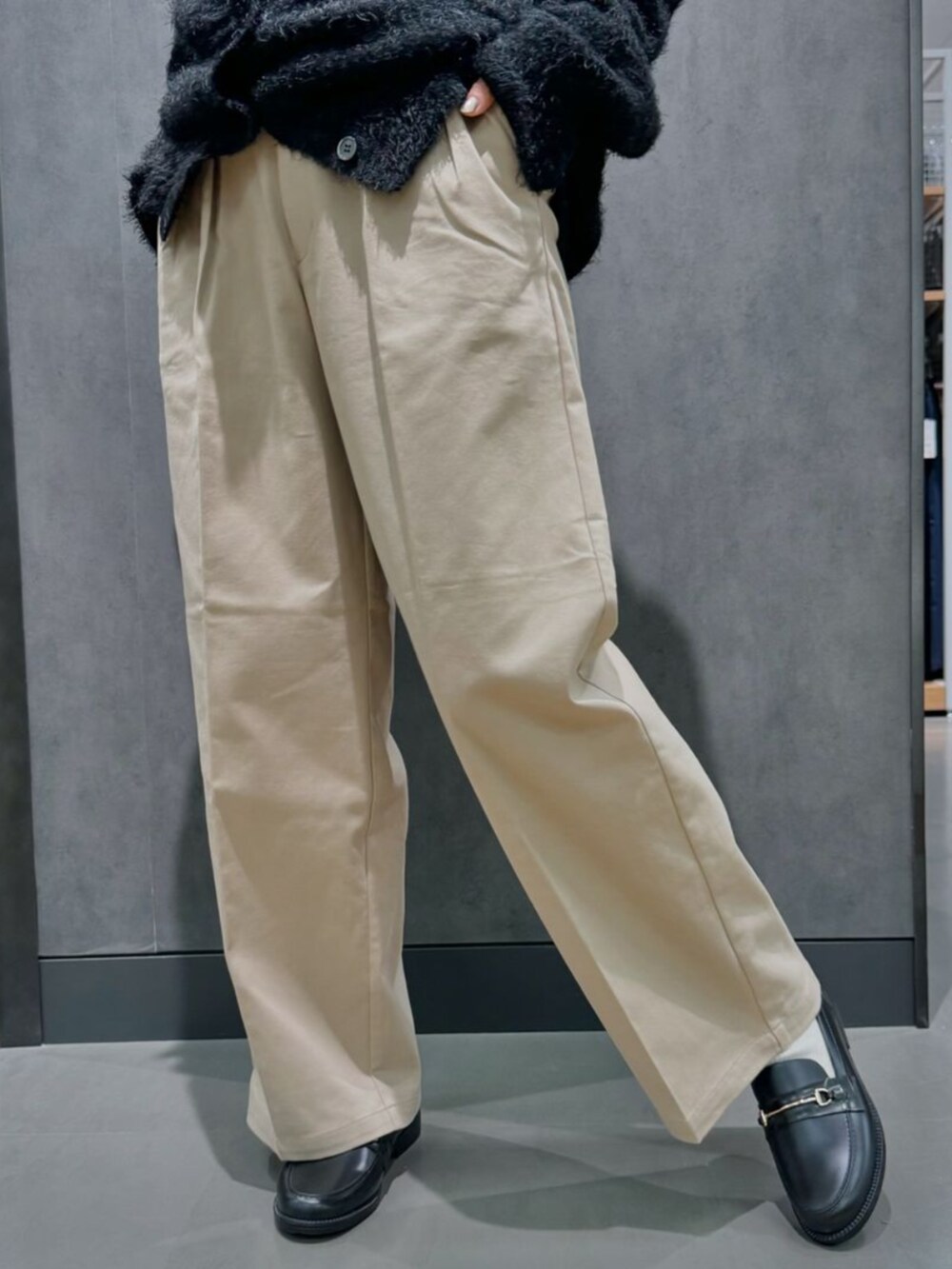 ベージュ系のチノパンツ、ブラック系のカーディガン/ボレロを着用したレディースの秋コーディネートの2枚目の写真