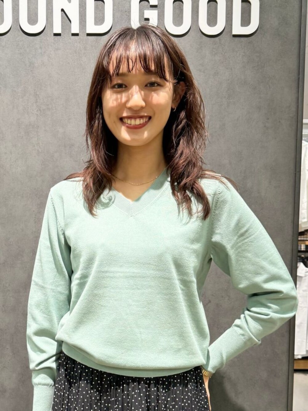 グリーン系のニット/セーター、グレー系のショルダーバッグ、グレー系のパンプスを着用したレディースの秋コーディネートの2枚目の写真