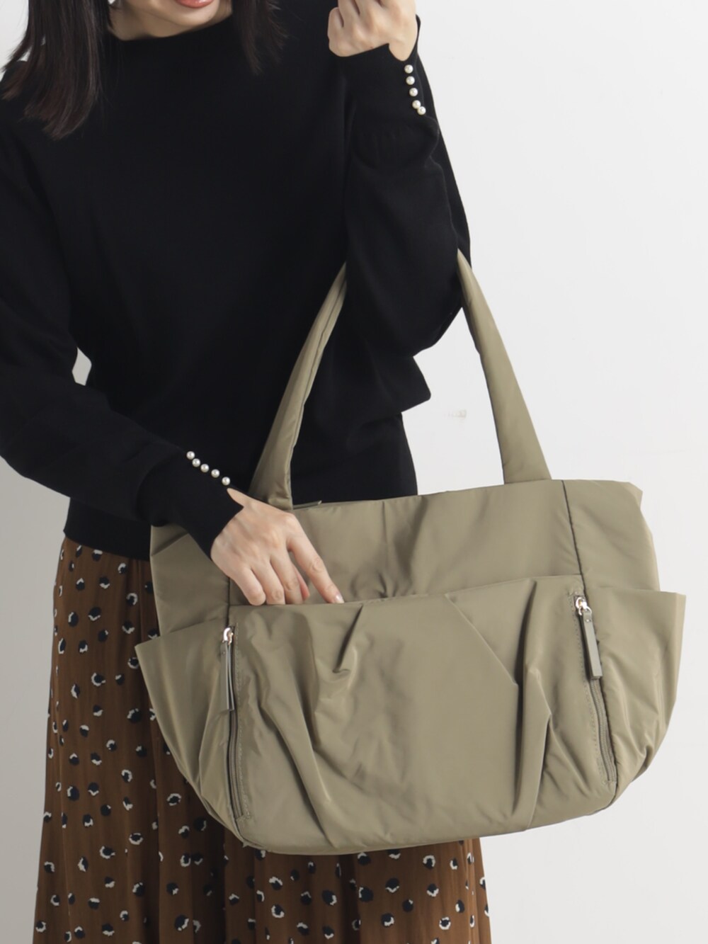 ベージュ系のトートバッグを着用したレディースの冬コーディネートの2枚目の写真