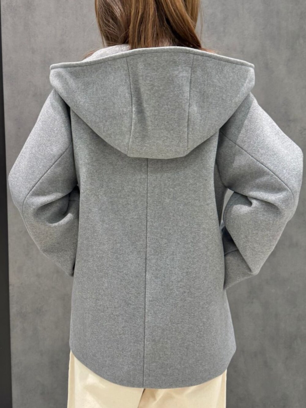 オレンジ系のニット/セーター、グレー系のその他アウターを着用したレディースの冬コーディネートの3枚目の写真