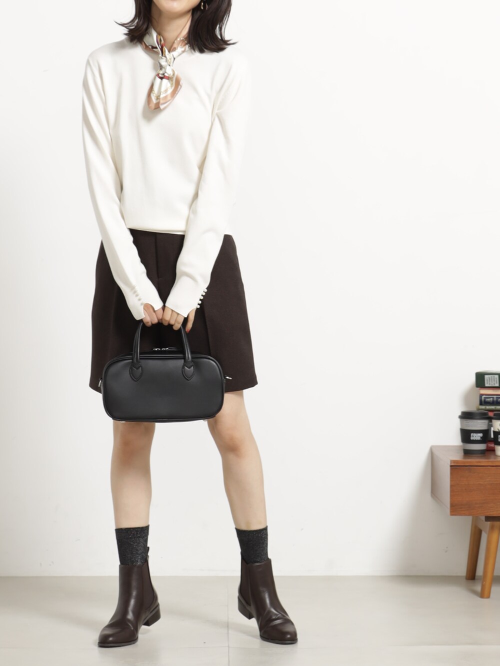 ブラウン系のその他パンツ、ホワイト系のニット/セーター、ブラック系のボストンバッグを着用したレディースの秋コーディネートの2枚目の写真