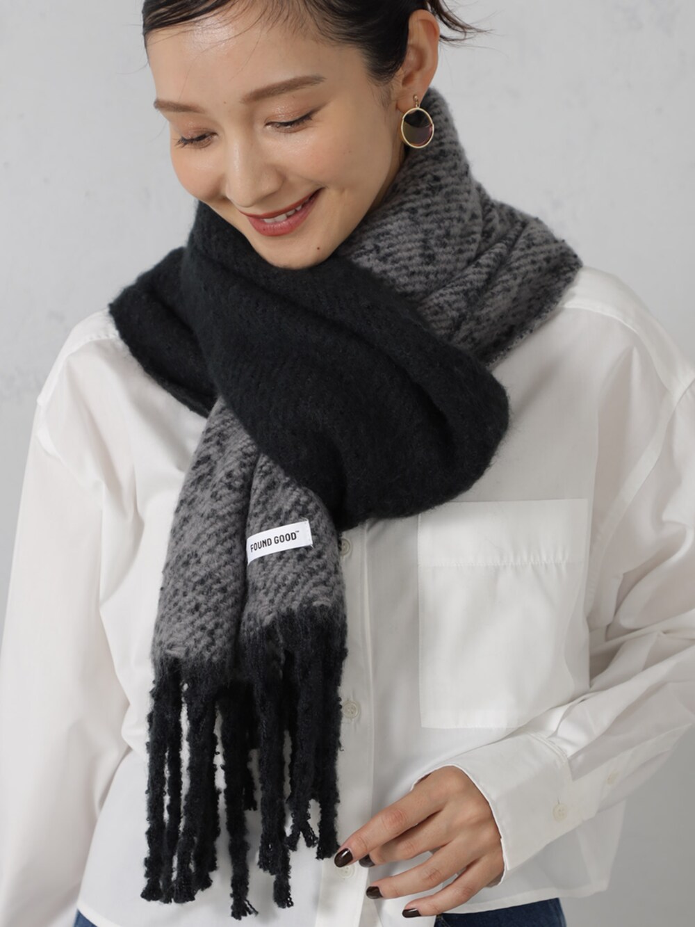 ブルー系のデニムパンツ、ブラック系のマフラーを着用したレディースの秋コーディネートの2枚目の写真