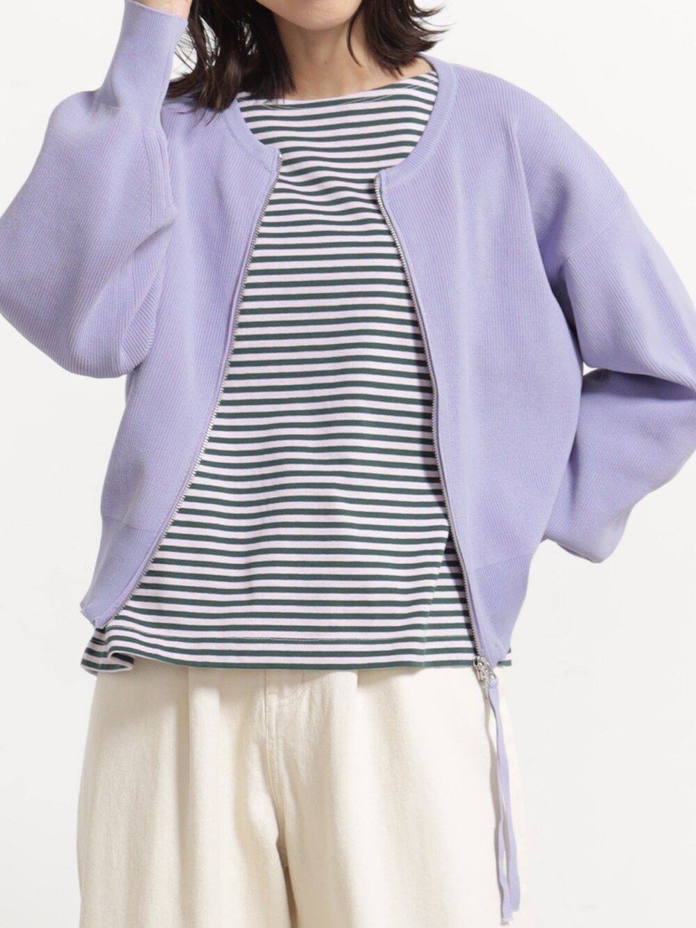 パープル系のブルゾン、ホワイト系のデニムパンツを着用したレディースの秋コーディネートの2枚目の写真