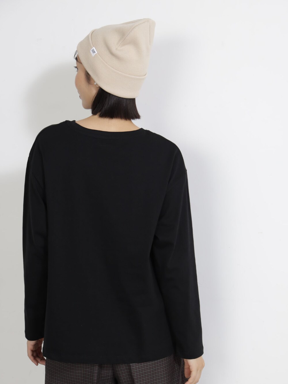 ブラック系のTシャツ/カットソー、ベージュ系のキャップを着用したレディースの秋コーディネートの2枚目の写真