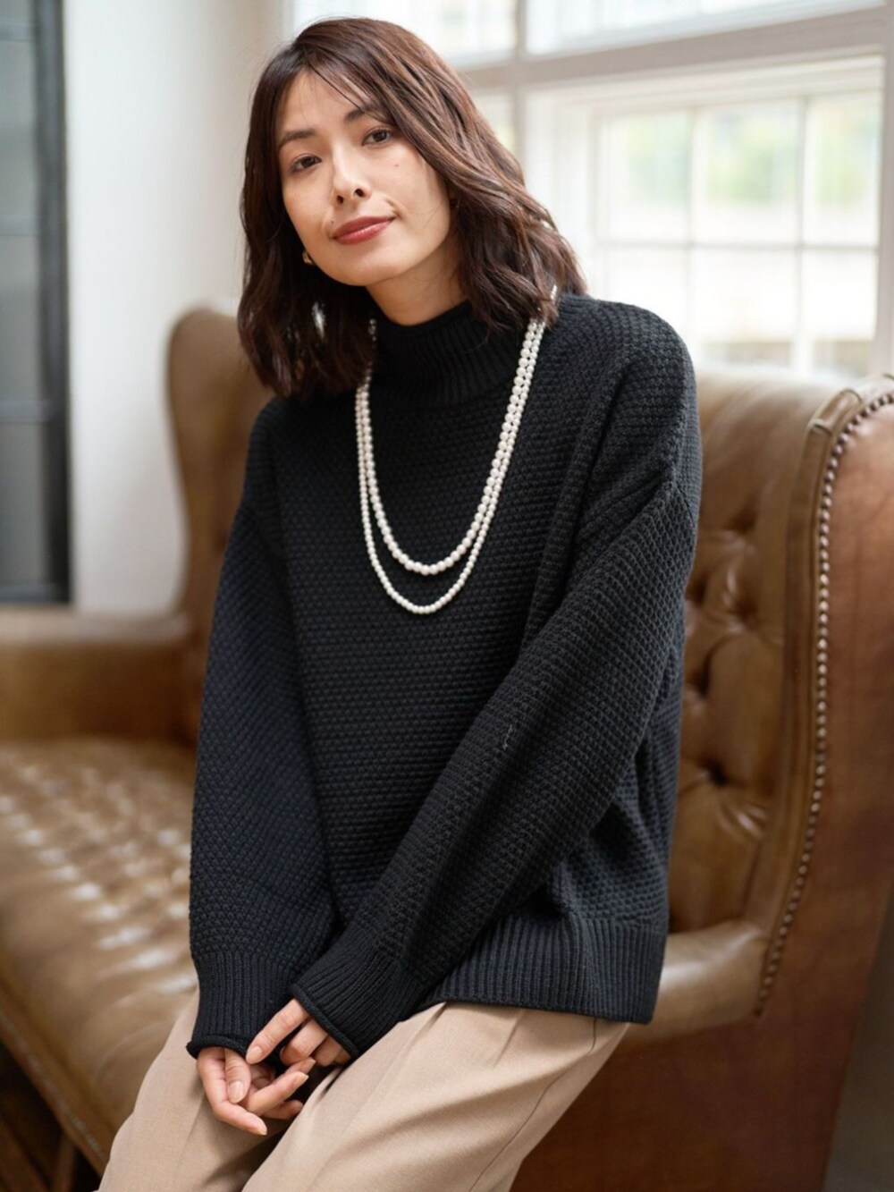 ブラック系のニット/セーターを着用したレディースの秋コーディネートの2枚目の写真