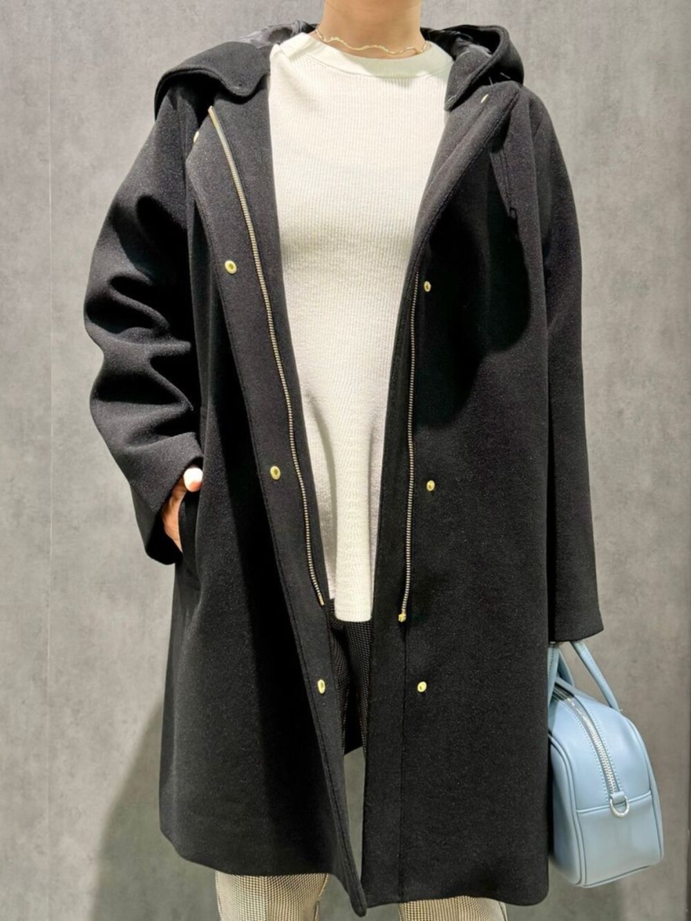 ブルー系のショルダーバッグ、ブラック系のブーツ、ブラック系のその他アウターを着用したレディースの秋コーディネートの2枚目の写真