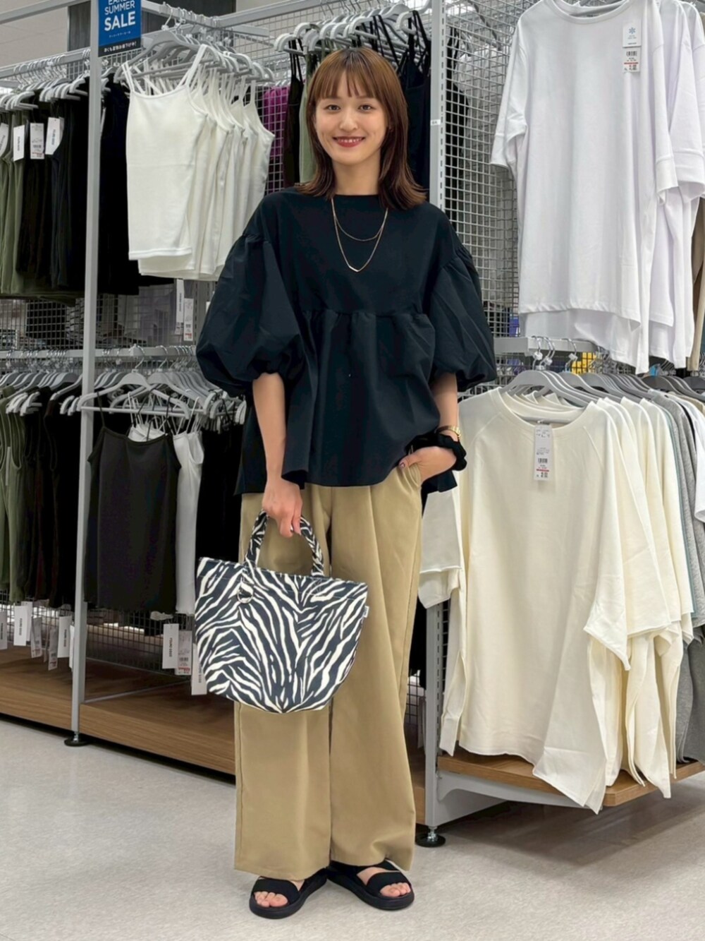 ブラック系のTシャツ/カットソーを着用したレディースの夏コーディネートの3枚目の写真