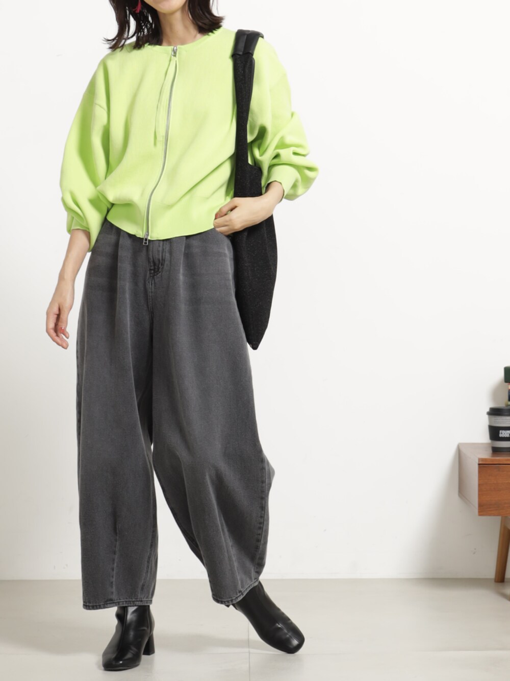 グレー系のデニムパンツ、グリーン系のブルゾンを着用したレディースの秋コーディネートの2枚目の写真