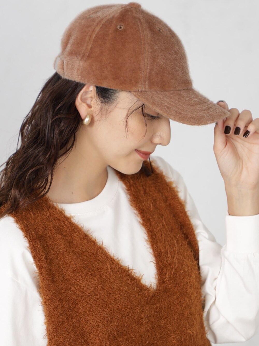 ブラウン系のニット/セーター、ブラウン系のキャップを着用したレディースの秋コーディネートの3枚目の写真