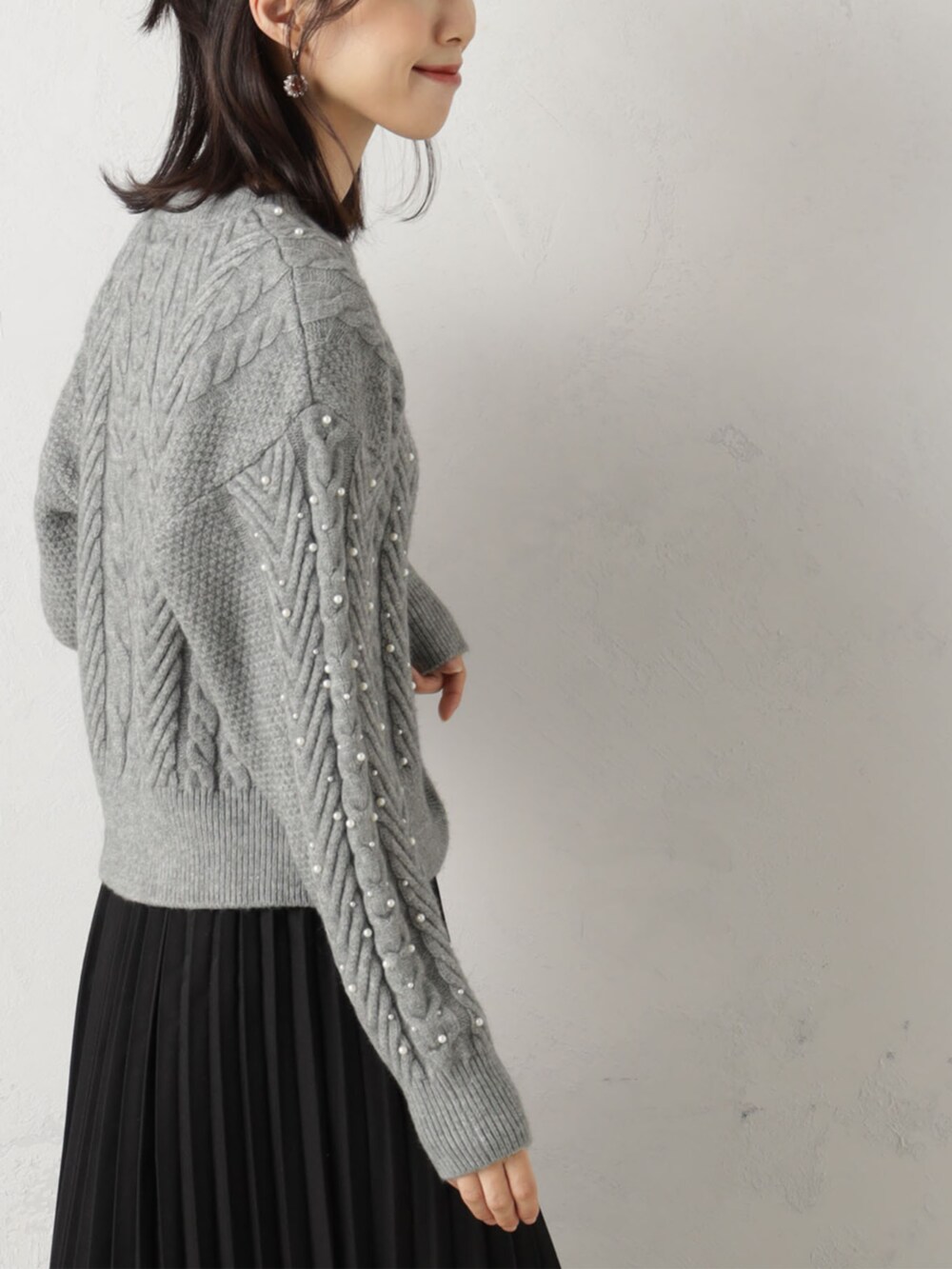 ブラック系のスカート、グレー系のニット/セーターを着用したレディースの冬コーディネートの3枚目の写真