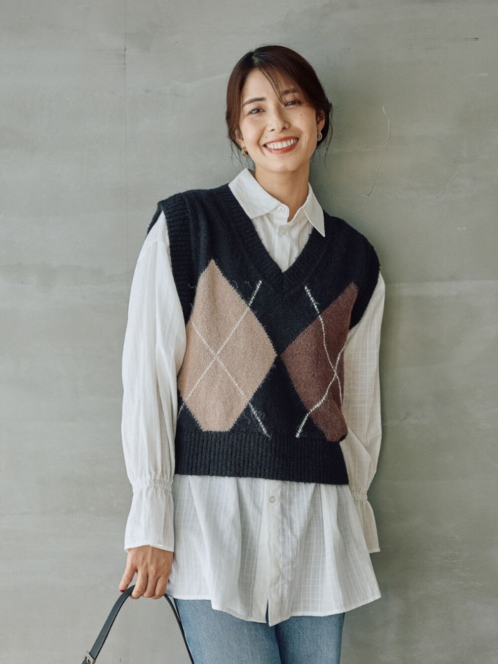 ブラック系のベストを着用したレディースの秋コーディネートの2枚目の写真