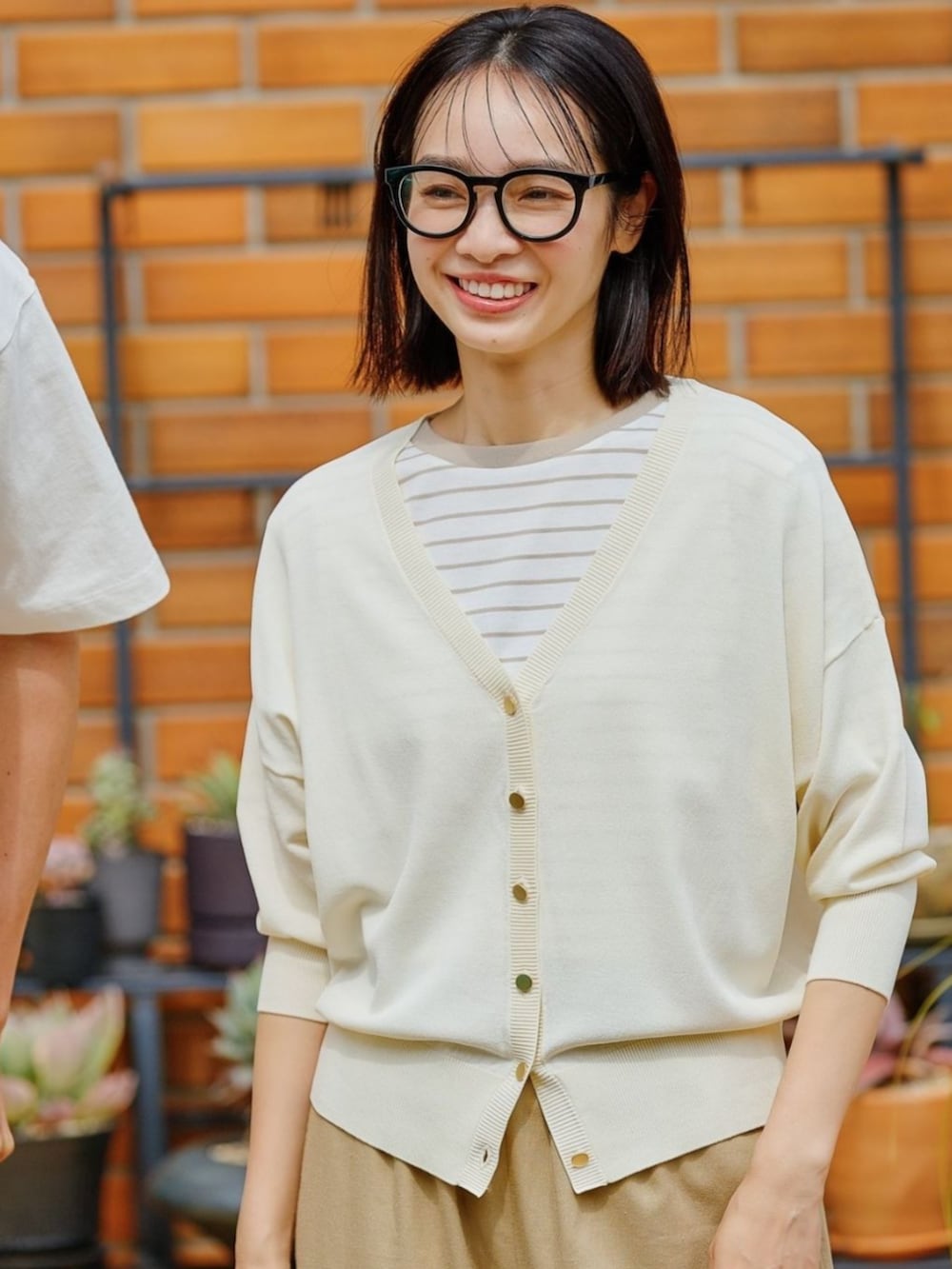 ベージュ系のニット/セーターを着用したレディースの春コーディネートの2枚目の写真