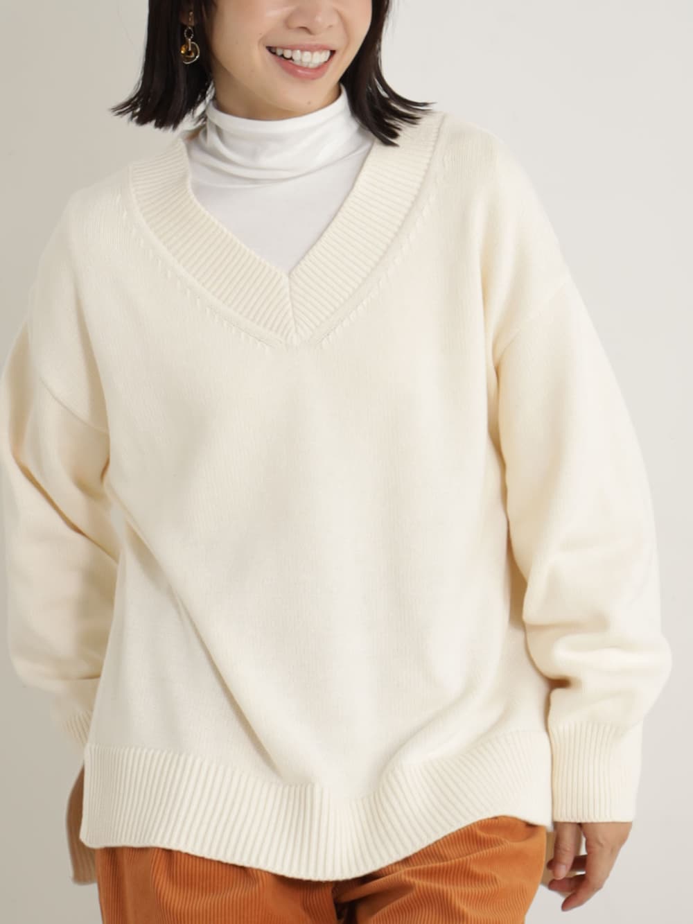 ベージュ系のブーツ、オレンジ系のその他パンツ、ベージュ系のニット/セーターを着用したレディースの冬コーディネートの2枚目の写真