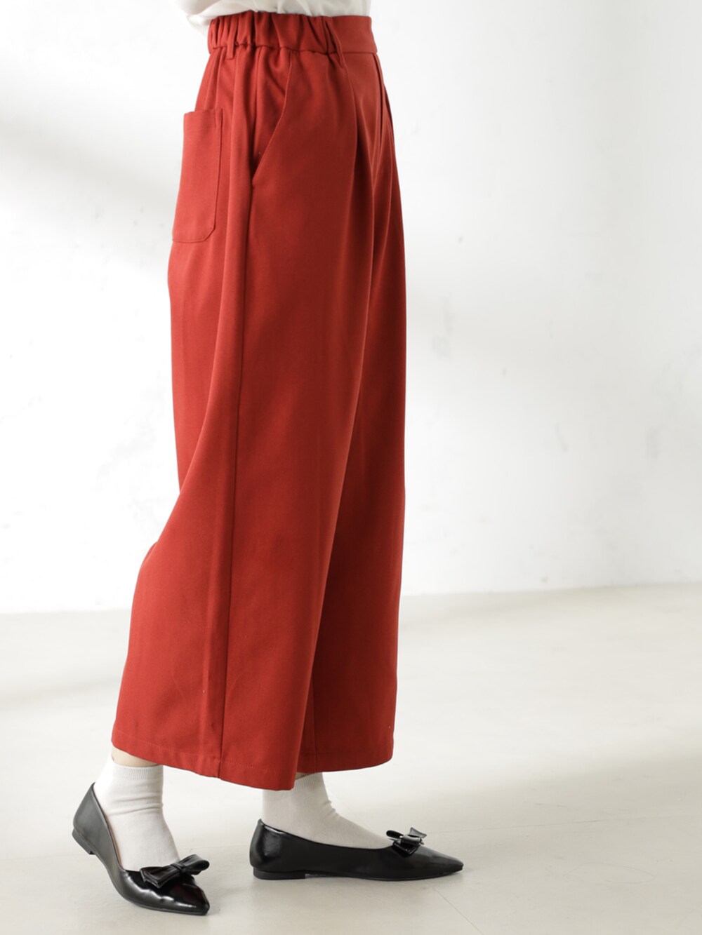 ブラック系のパンプス、ホワイト系のTシャツ/カットソー、オレンジ系のその他パンツを着用したレディースの冬コーディネートの3枚目の写真