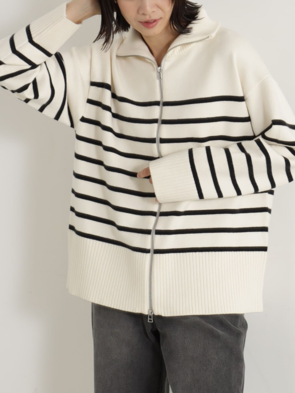 グレー系のカーディガン/ボレロ、グレー系のデニムパンツを着用したレディースの冬コーディネートの2枚目の写真