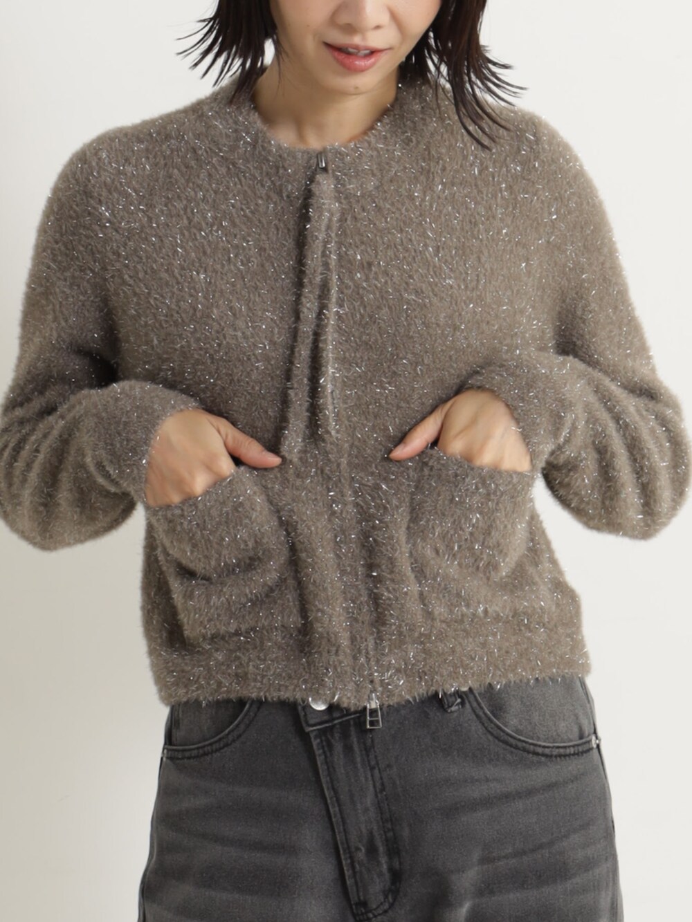 ブラック系のパンプス、ブラウン系のカーディガン/ボレロ、グレー系のデニムパンツを着用したレディースの冬コーディネートの2枚目の写真