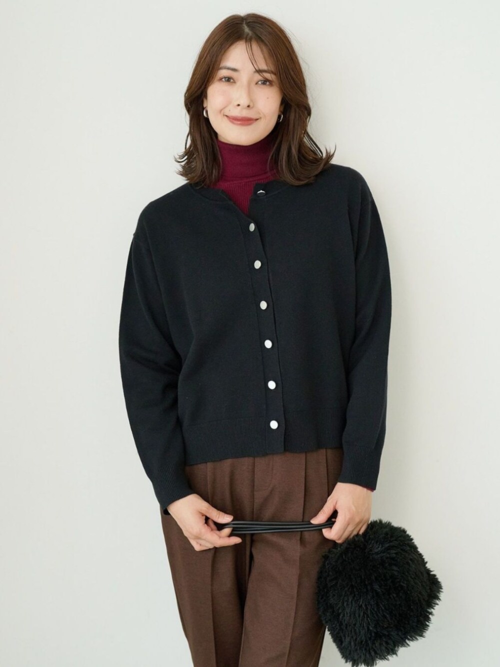 ブラック系のカーディガン/ボレロを着用したレディースの冬コーディネートの2枚目の写真