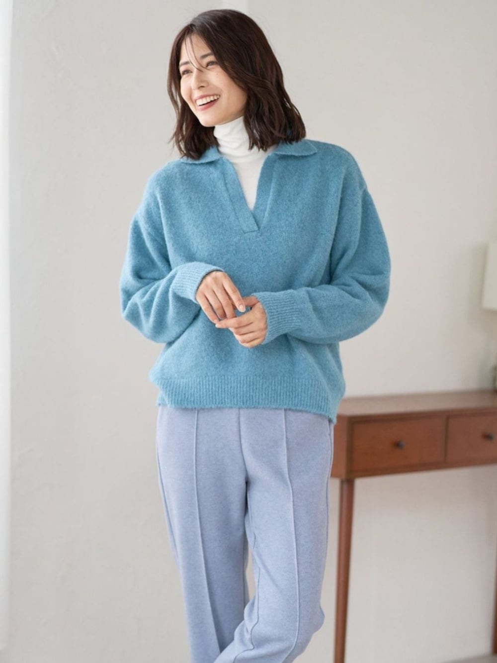 ブルー系のニット/セーターを着用したレディースの冬コーディネートの2枚目の写真