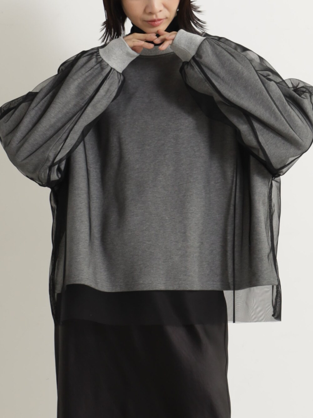 ベージュ系のブーツ、ブラック系のスカート、グレー系のTシャツ/カットソーを着用したレディースの冬コーディネートの2枚目の写真