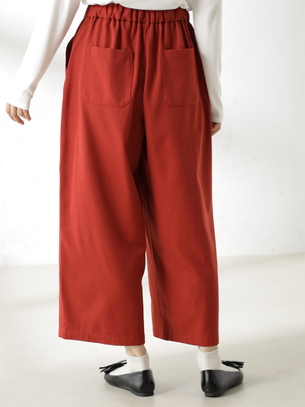 ブラック系のパンプス、ホワイト系のTシャツ/カットソー、オレンジ系のその他パンツを着用したレディースの冬コーディネートの4枚目の写真