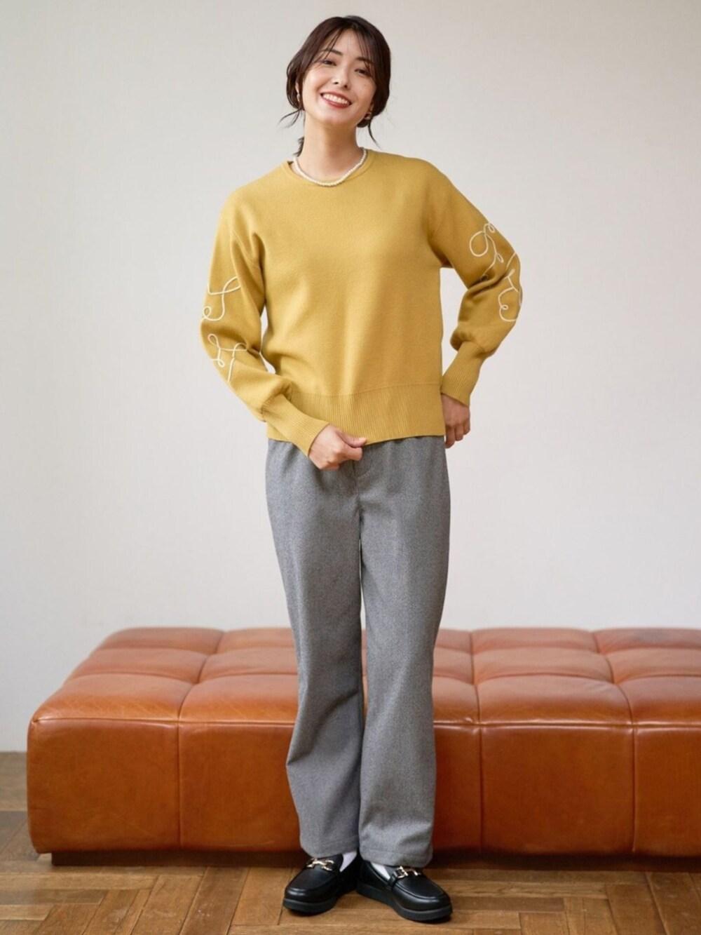 イエロー系のニット/セーターを着用したレディースの秋コーディネートの2枚目の写真
