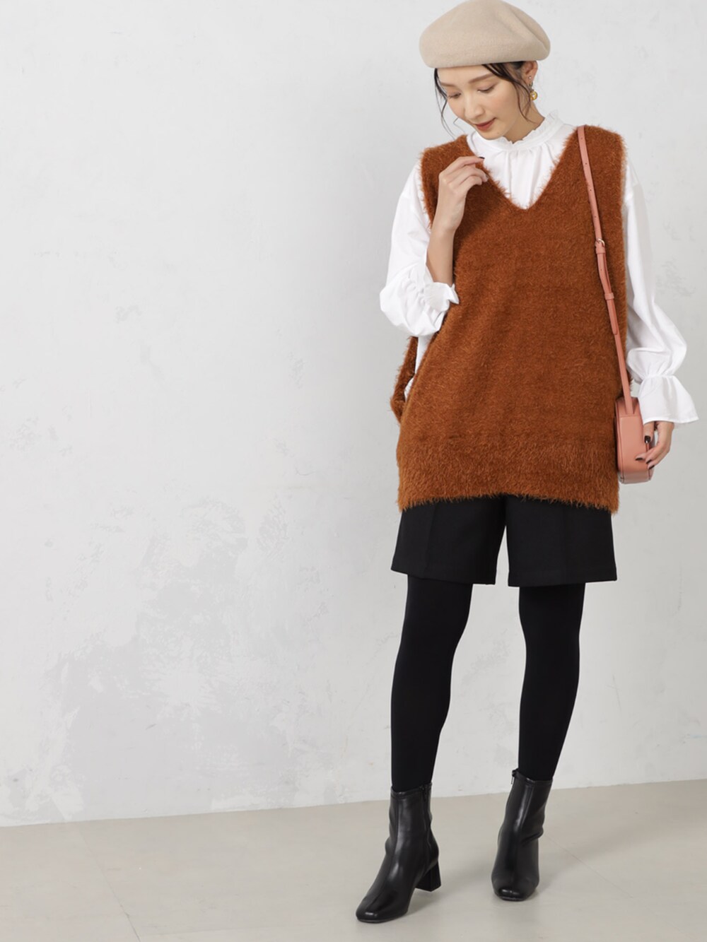 ブラウン系のニット/セーター、ベージュ系のハンチング/ベレー帽、ベージュ系のマフラーを着用したレディースの秋コーディネートの4枚目の写真