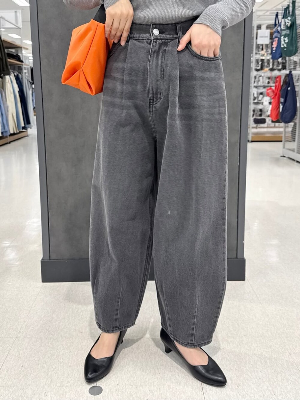 グレー系のデニムパンツ、ブラック系のパンプス、ブルー系のニット/セーターを着用したレディースの冬コーディネートの2枚目の写真