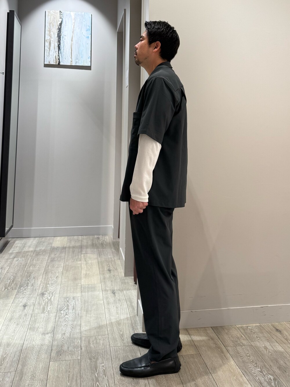 グレー系のスラックス、ホワイト系のTシャツ/カットソーを着用したメンズの秋コーディネートの3枚目の写真