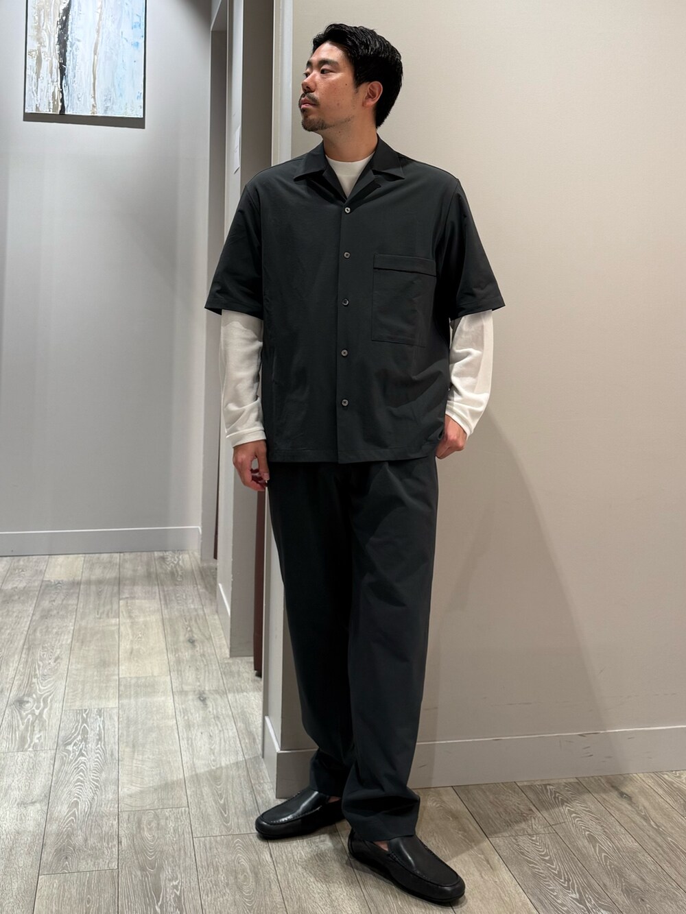 グレー系のスラックス、ホワイト系のTシャツ/カットソーを着用したメンズの秋コーディネートの2枚目の写真