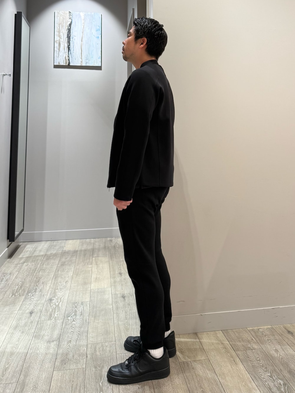 ブラック系のブルゾン、ブラック系のスラックス、ブラウン系のTシャツ/カットソーを着用したメンズの秋コーディネートの2枚目の写真