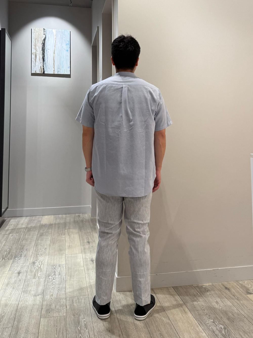 ブルー系のシャツ/ブラウス、ブラック系のTシャツ/カットソー、グレー系のスラックスを着用したメンズの夏コーディネートの3枚目の写真