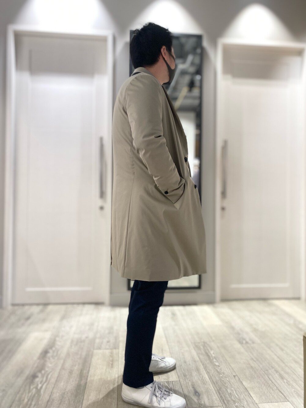 ベージュ系のチェスターコート、ブルー系のテーラードジャケット、ブルー系のスラックスを着用したメンズの冬コーディネートの2枚目の写真