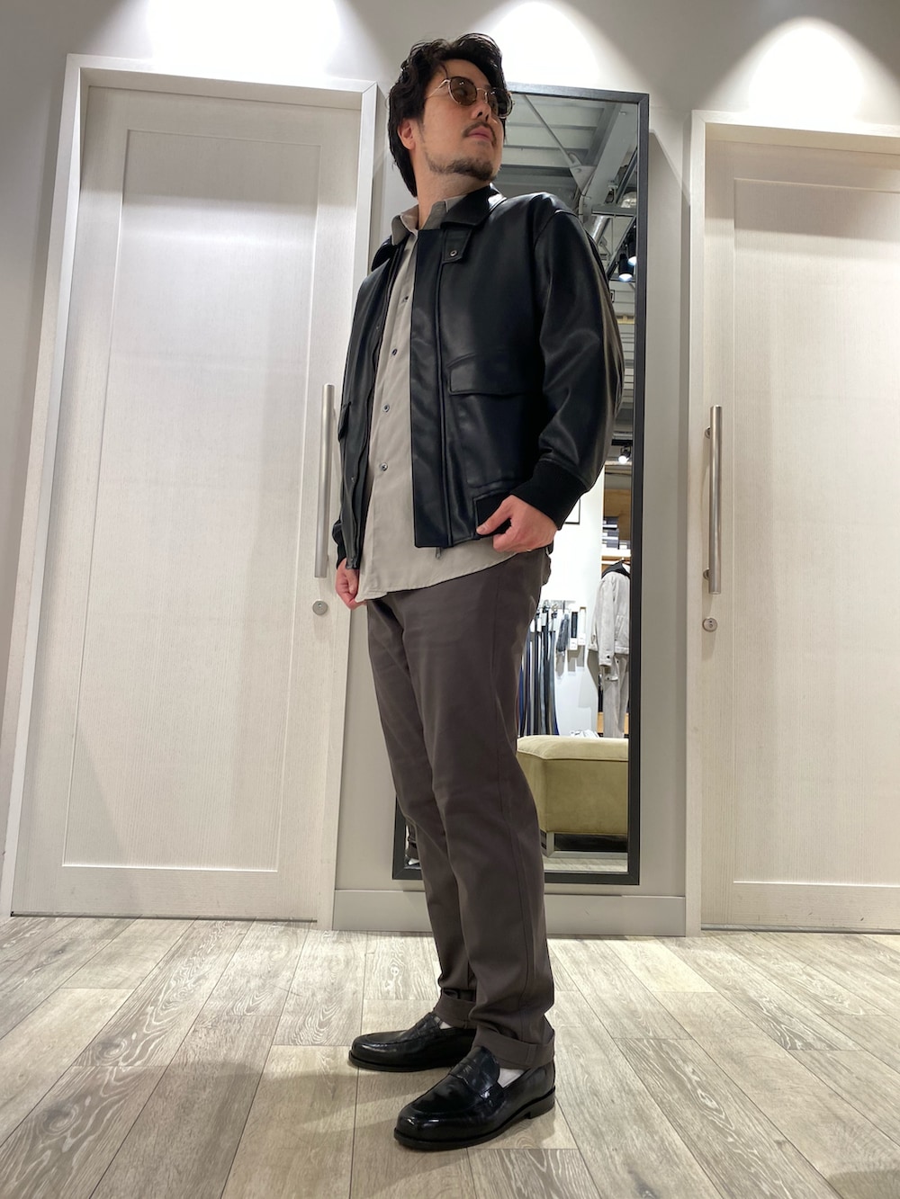 ブラック系のライダースジャケット、ベージュ系のシャツ/ブラウス、グレー系のチノパンツを着用したメンズの秋コーディネートの3枚目の写真