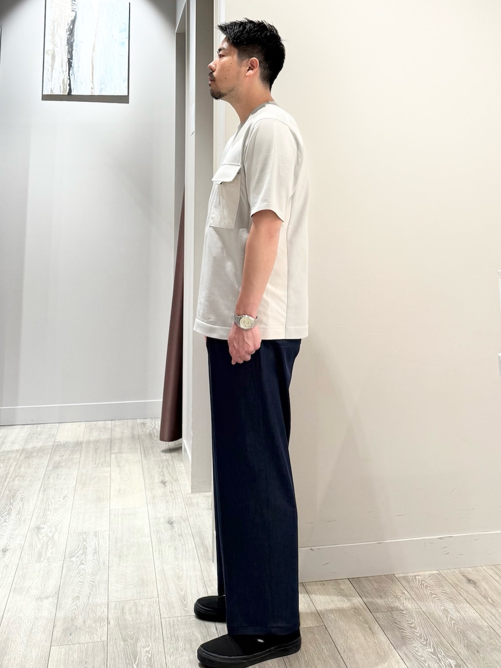 グレー系のニット/セーター、ブルー系のスラックスを着用したメンズの春コーディネートの4枚目の写真