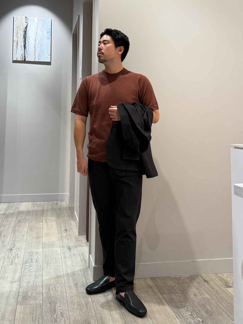 ブラウン系のTシャツ/カットソー、ブラック系のスラックス、ブラック系のセットアップを着用したメンズの秋コーディネートの2枚目の写真