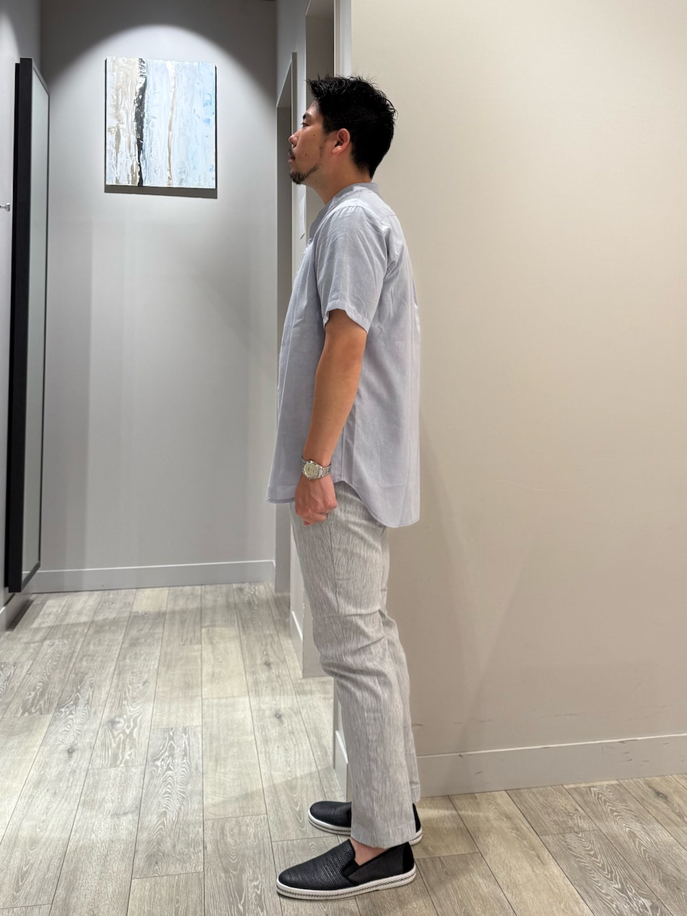 ブルー系のシャツ/ブラウス、ブラック系のTシャツ/カットソー、グレー系のスラックスを着用したメンズの夏コーディネートの2枚目の写真