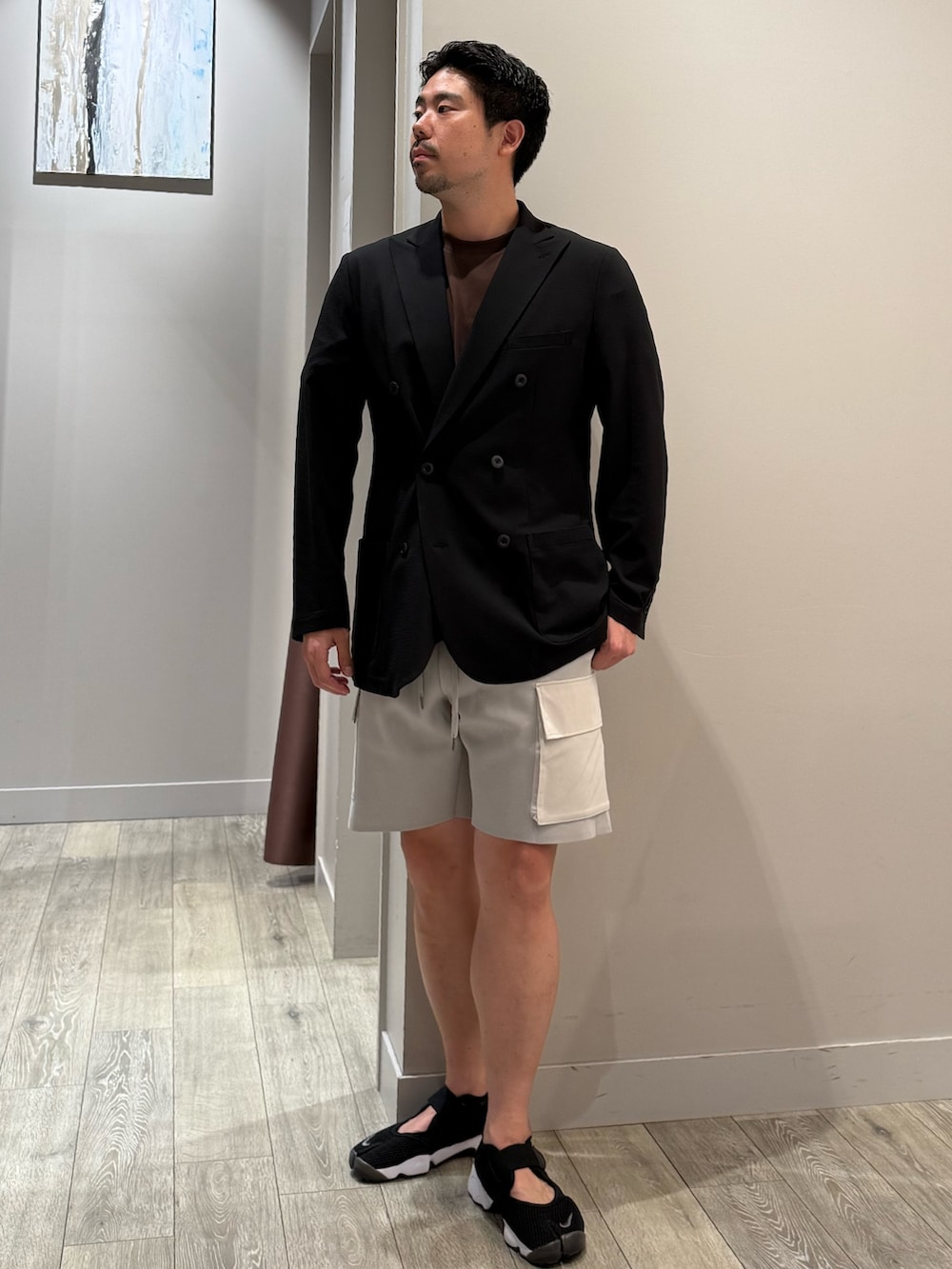 ブラック系のテーラードジャケット、ブラウン系のTシャツ/カットソー、グレー系のその他パンツを着用したメンズの夏コーディネートの2枚目の写真