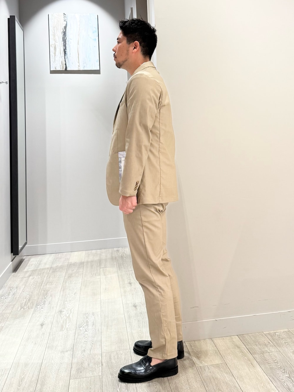 ベージュ系のテーラードジャケット、ベージュ系のスラックス、ベージュ系のセットアップを着用したメンズの夏コーディネートの2枚目の写真