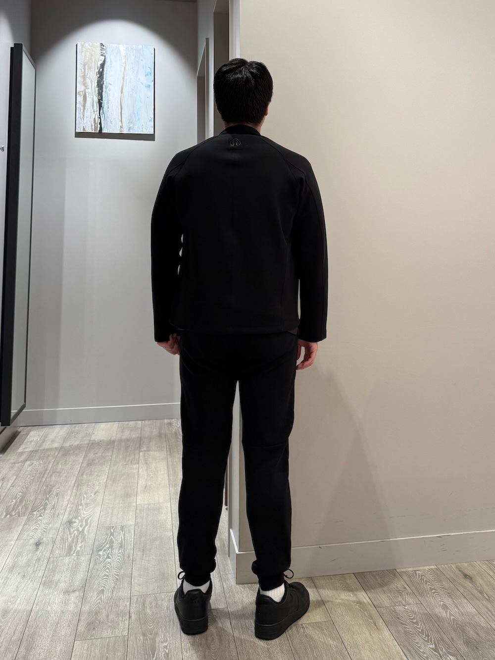 ブラック系のブルゾン、ブラック系のスラックス、ブラウン系のTシャツ/カットソーを着用したメンズの秋コーディネートの3枚目の写真
