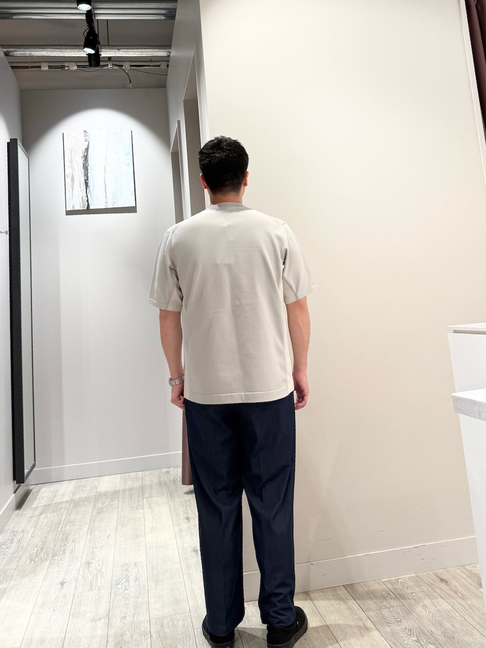 グレー系のニット/セーター、ブルー系のスラックスを着用したメンズの春コーディネートの3枚目の写真