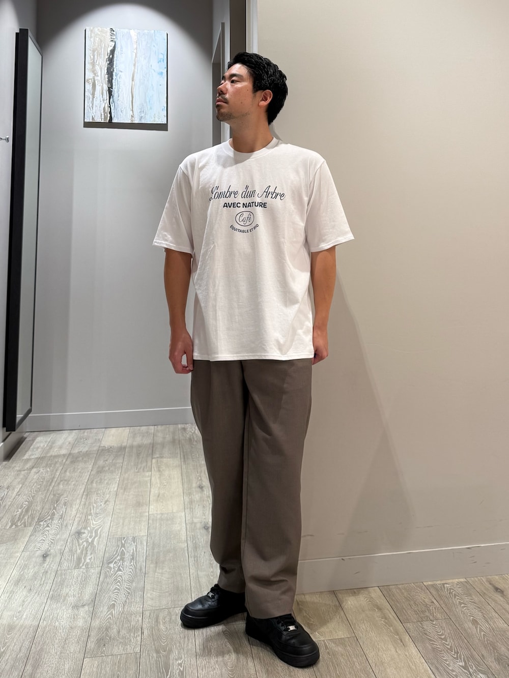 ホワイト系のTシャツ/カットソー、ブラウン系のスラックス、ブラック系のシャツ/ブラウスを着用したメンズの秋コーディネートの4枚目の写真