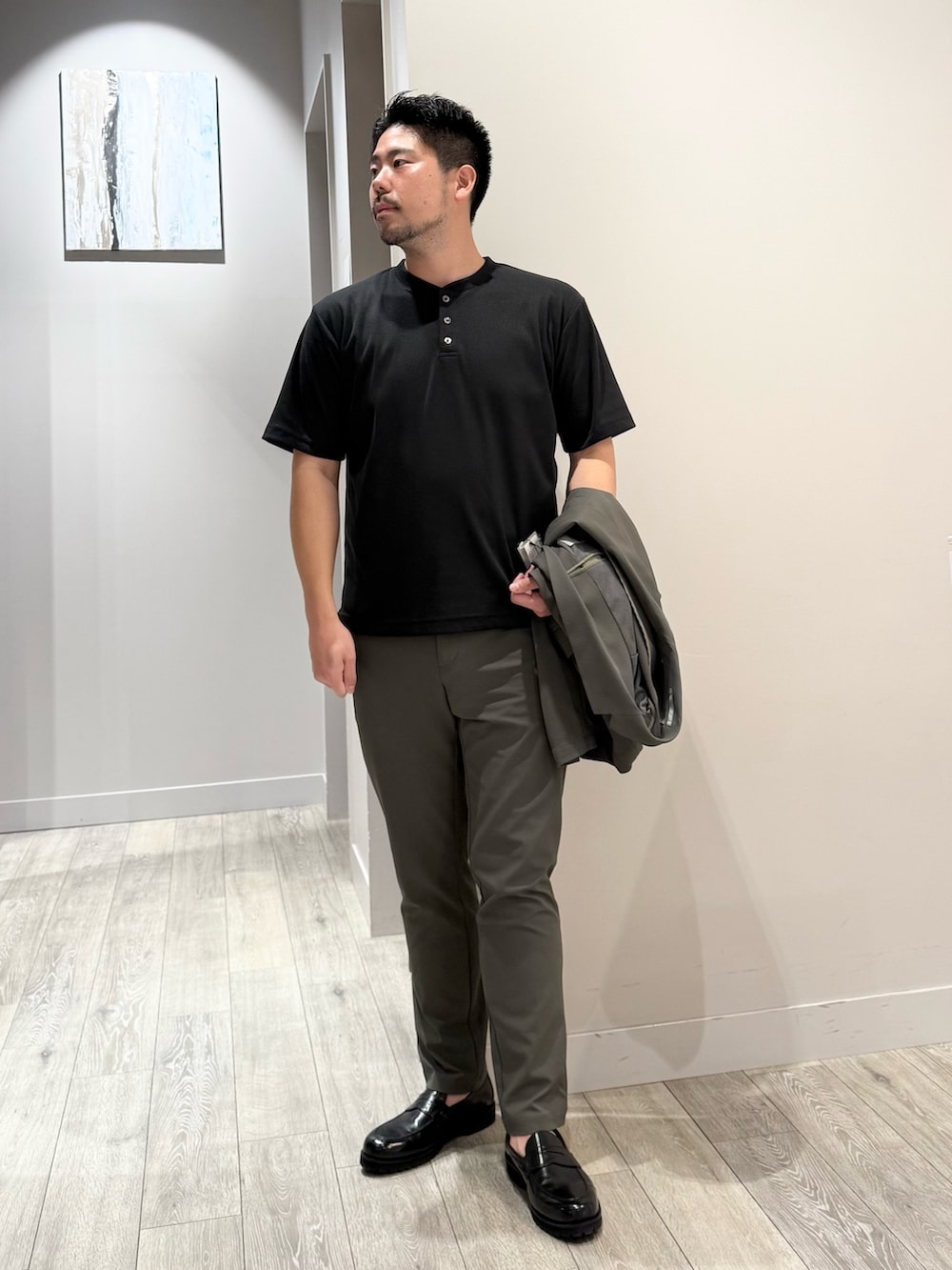 グリーン系のテーラードジャケット、ブラック系のTシャツ/カットソー、グリーン系のスラックスを着用したメンズの夏コーディネートの4枚目の写真