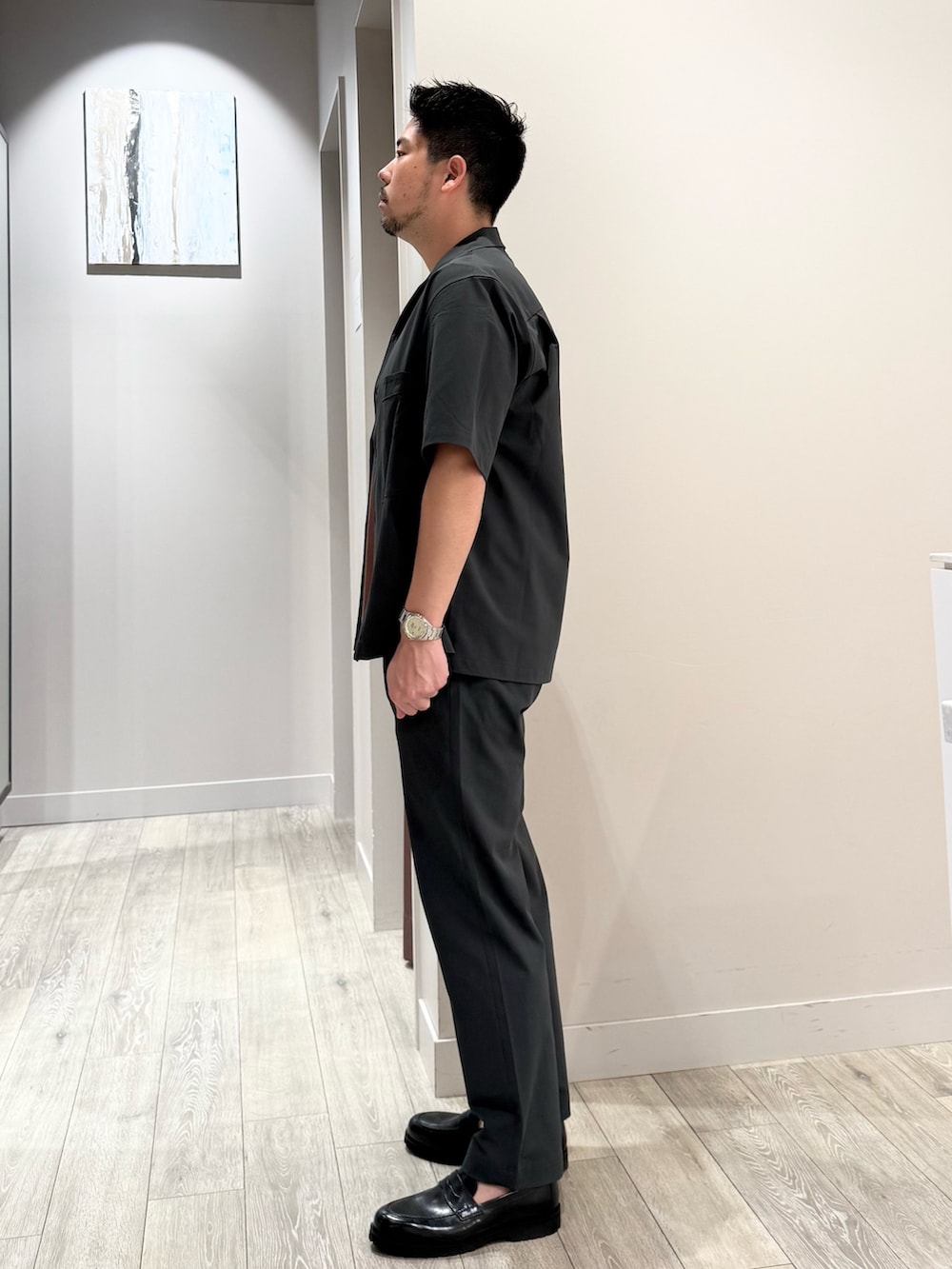 ブラウン系のTシャツ/カットソー、グレー系のスラックスを着用したメンズの夏コーディネートの2枚目の写真