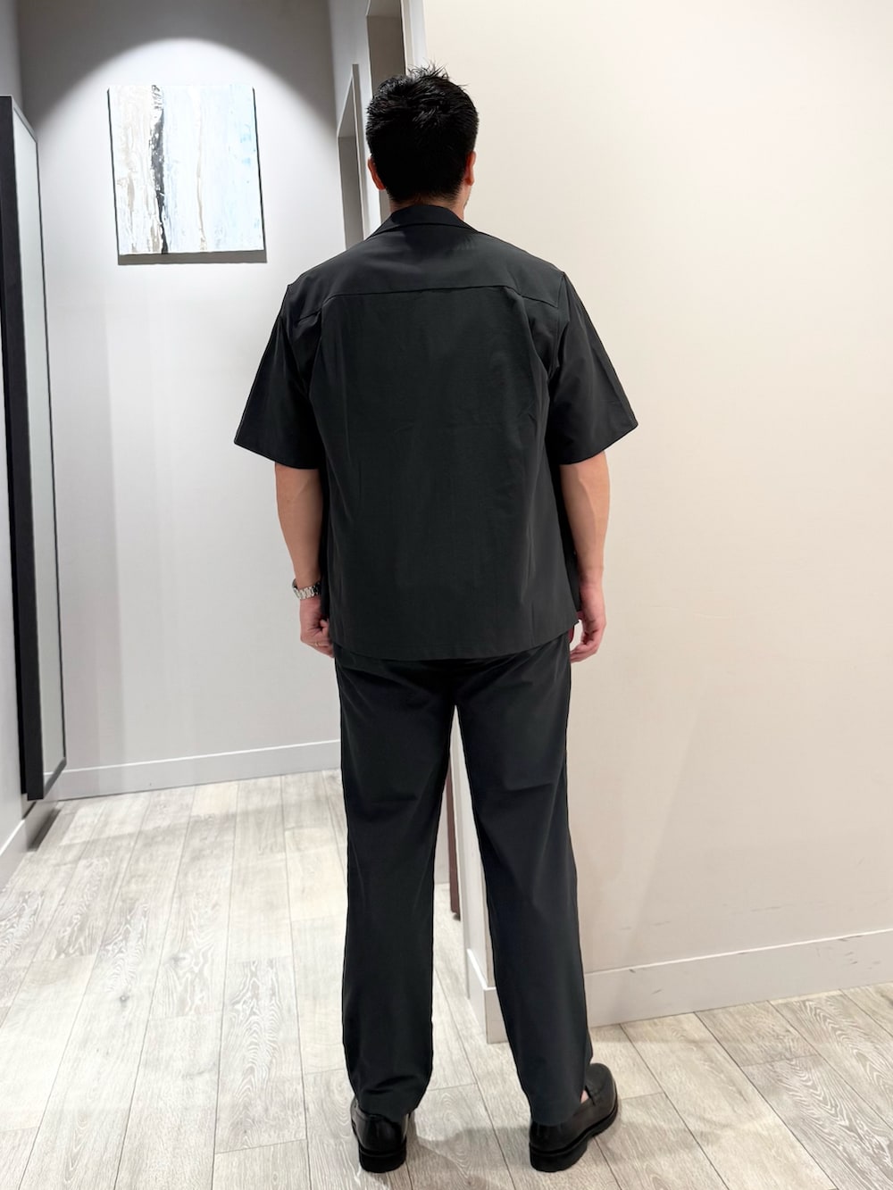 ブラウン系のTシャツ/カットソー、グレー系のスラックスを着用したメンズの夏コーディネートの3枚目の写真
