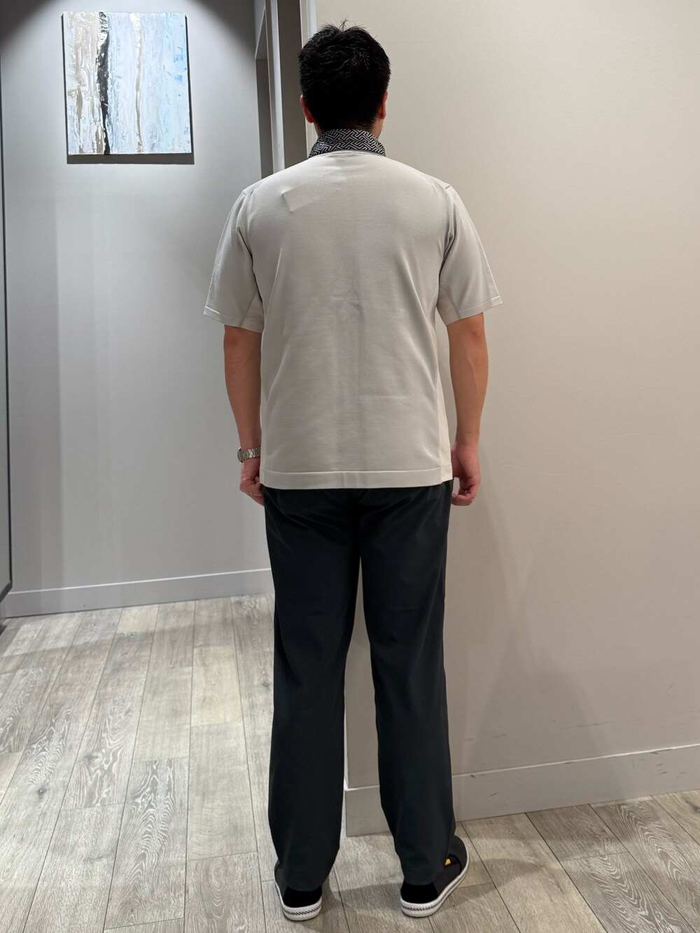 グレー系のニット/セーター、グレー系のスラックス、ブラック系のストール/ショールを着用したメンズの夏コーディネートの3枚目の写真