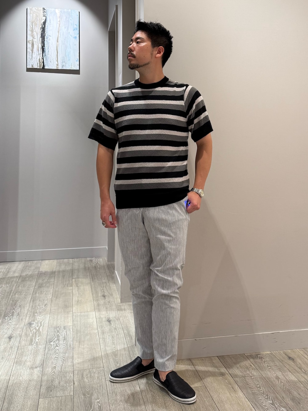 ブルー系のシャツ/ブラウス、ブラック系のTシャツ/カットソー、グレー系のスラックスを着用したメンズの夏コーディネートの4枚目の写真